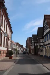 Eine ruhige Straße mit traditionellen Fachwerkhäusern und blauem Himmel. Die Architektur spiegelt den Charme einer deutschen Kleinstadt wider.