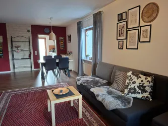 Wohnzimmer mit einem gemütlichen Sofa und einem kleinen Tisch und hübscher Wanddekoration.