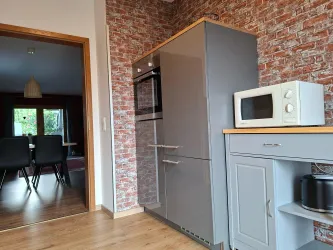 Eine moderne Küche mit einem großen Kühlschrank  (auch ein Gefrierfach ist vorhanden) und einer Mikrowelle.