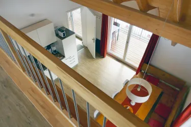 Eine moderne Wohnung mit einer offenen Küche und einem Essbereich. Große Fenster sorgen für viel Tageslicht.