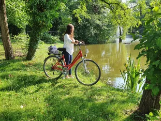 Weinprinzessin mit dem Fahrrad am Schwanenweiher in Kandel