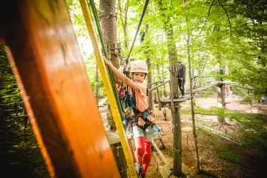 Kind klettert entlang eines Parcours im Abenteuerpark Kandel