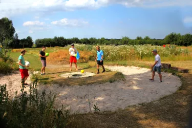 Junge Männer versuchen einen Ball in ein Hole zu platzieren