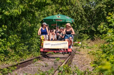 Eine kleine Gruppe radelt auf einer Draisine