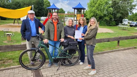 Vertreter der lokalen Politik und des Tourismus übergeben die Urkunde an das Campingresort