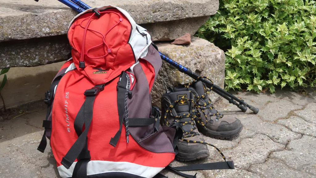 Rucksack mit Wanderschuhen und Stöcken