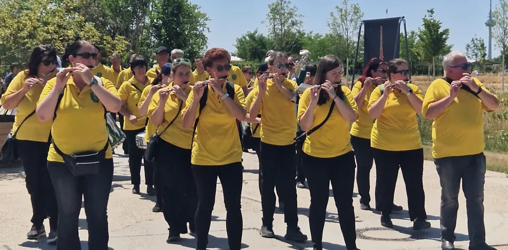 Der Fanfaren- und Spielmannszug Schaidt marschiert Instrumente spielend  über das BUGA-Gelände