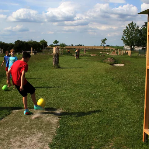 Junge spielt Golf mit dem Fussball