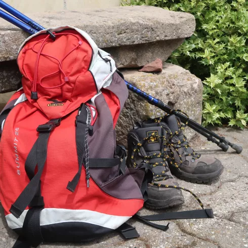 Rucksack mit Wanderschuhen und Stöcken